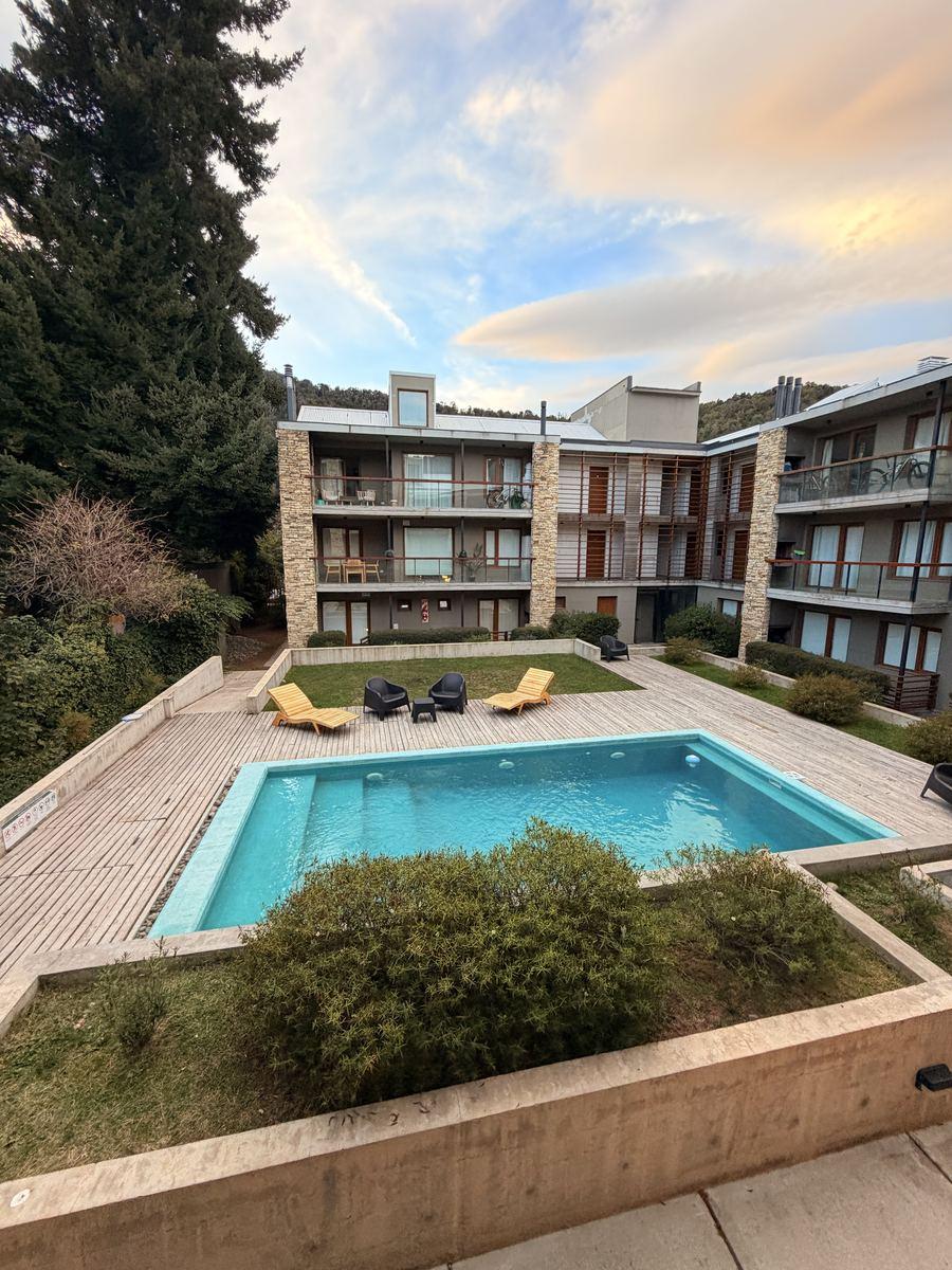 Edificio Aliwen con jardín y piscina al atardecer en San Martín de los Andes