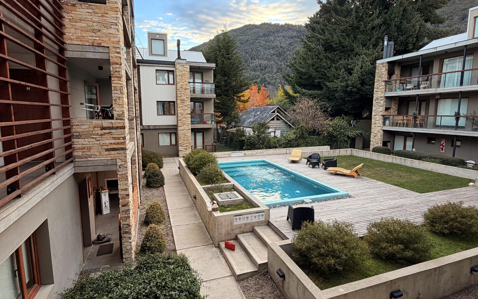 Patio del edificio Aliwen con piscina y vista a la montaña en San Martín de los Andes